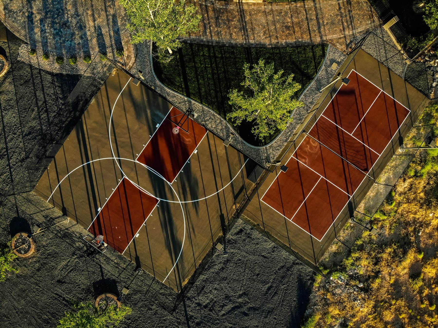 Tennis and basketball courts built into the lava rock at a Nielson Development custom home