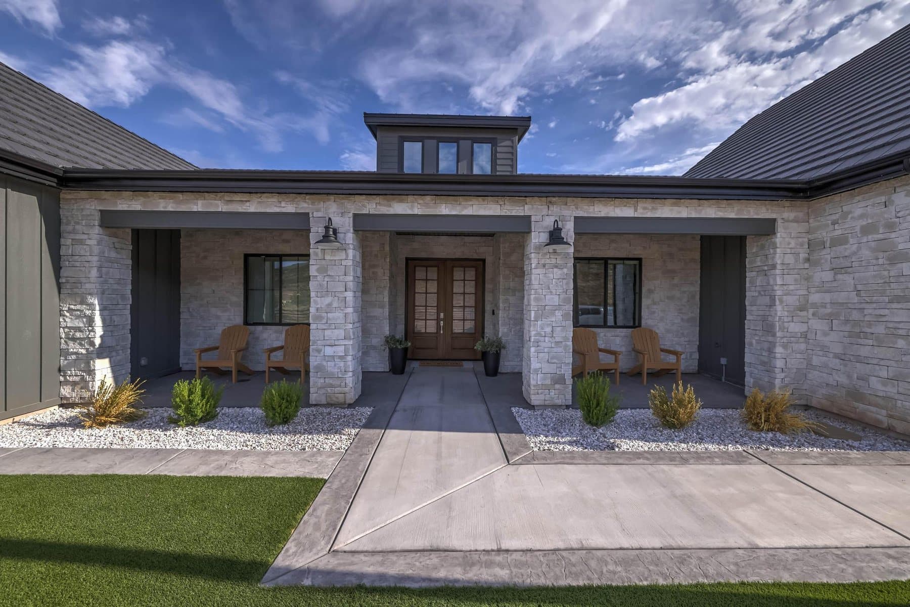 The front elevation — board-and-batten and stone under a standing-seam roof