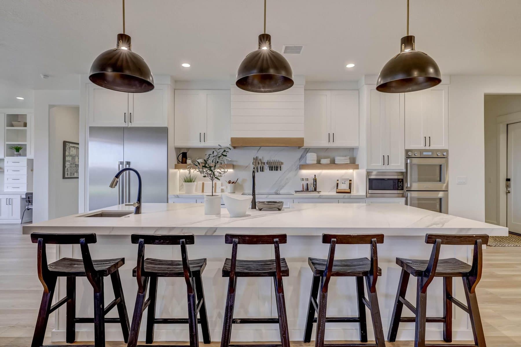 The kitchen — oversized quartz island, pendant lighting and bar seating