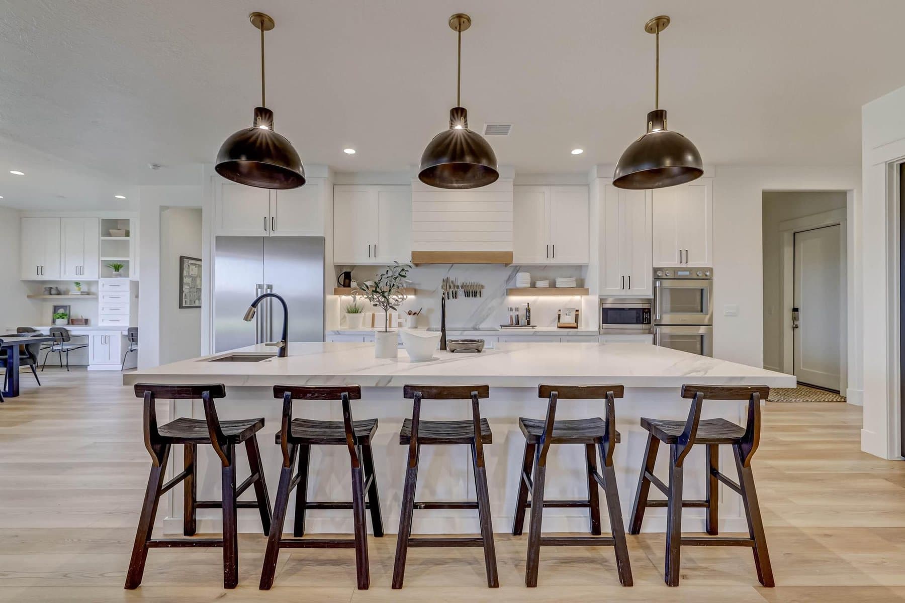 The kitchen — oversized quartz island, pendant lighting and bar seating