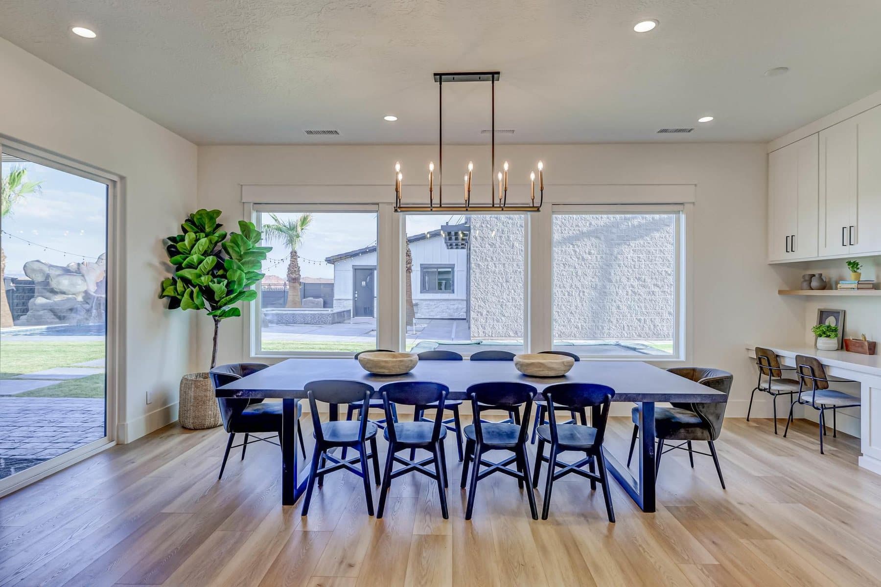 The dining room, table for ten under a linear chandelier