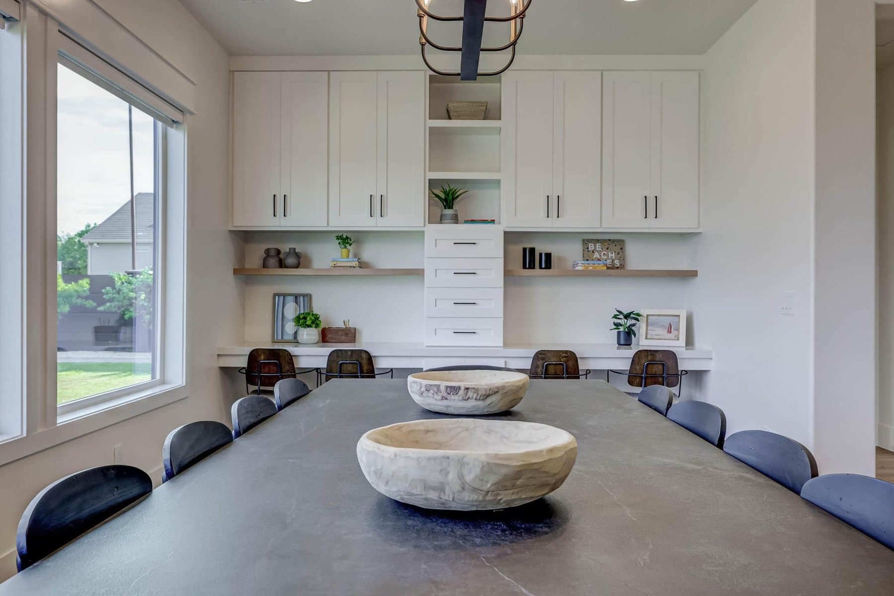 The dining room, table for ten under a linear chandelier