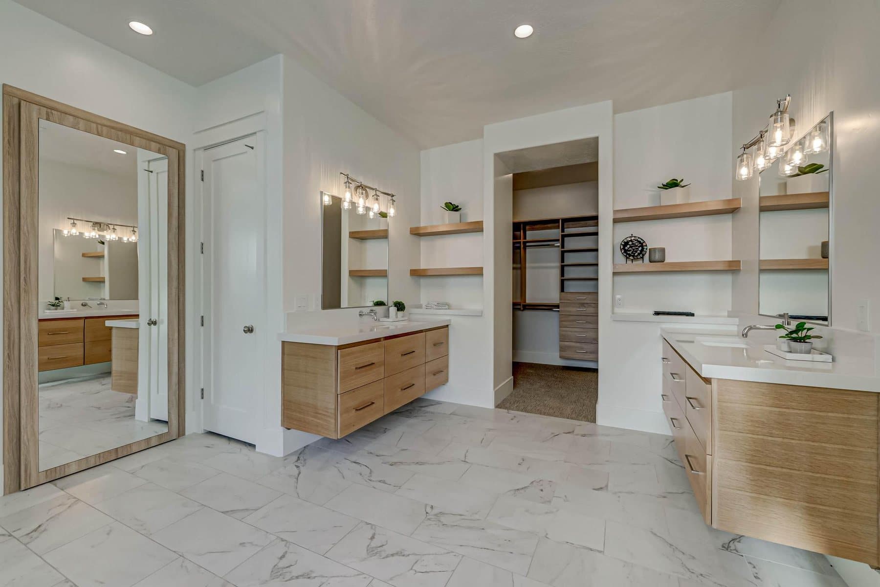The primary bath — double vanities, freestanding tub and tiled walk-in shower