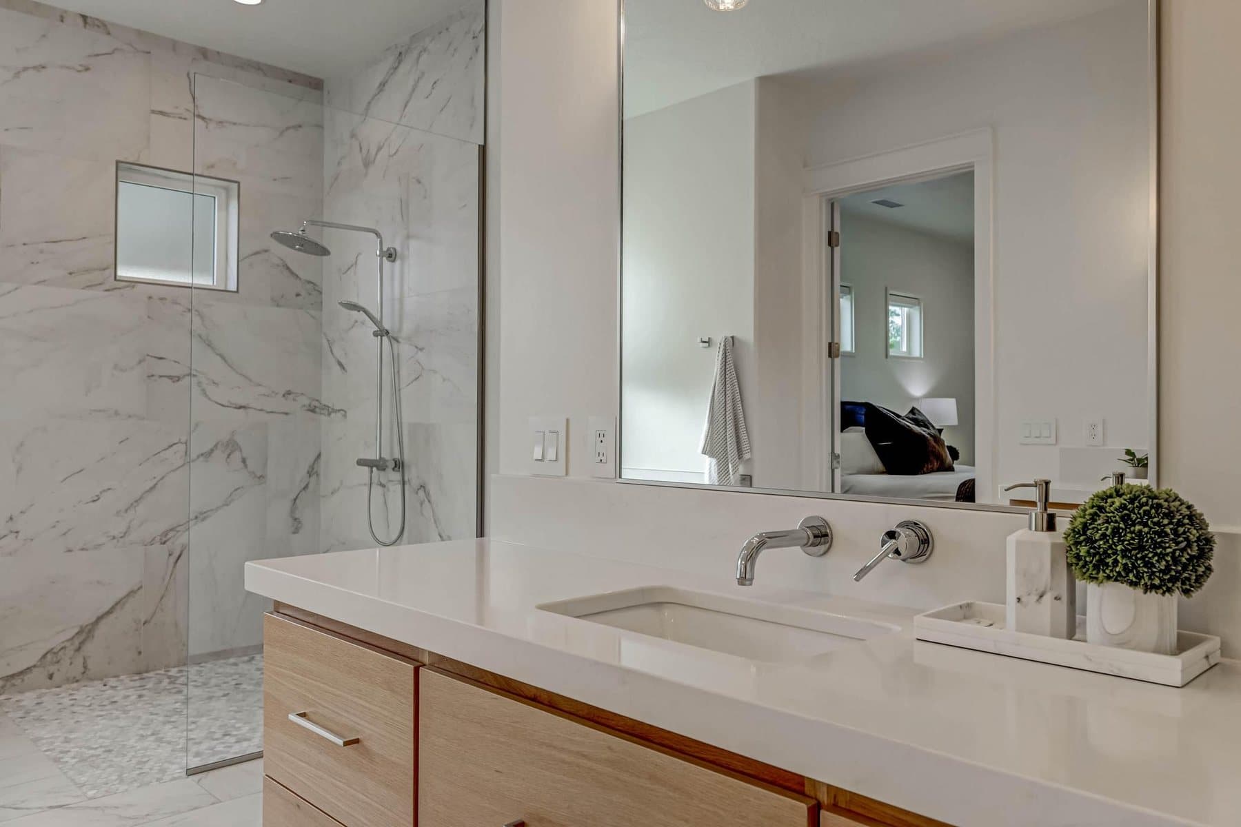 The primary bath — double vanities, freestanding tub and tiled walk-in shower
