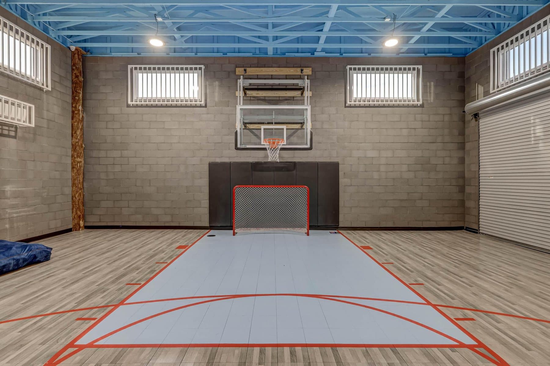 The indoor sport court in the rec building — climbing wall, slide and roll-up doors