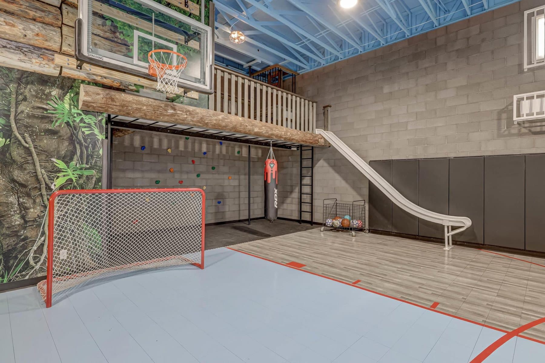 The indoor sport court in the rec building — climbing wall, slide and roll-up doors