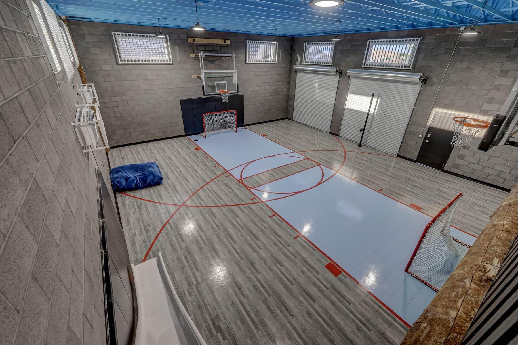 The indoor sport court in the rec building — climbing wall, slide and roll-up doors