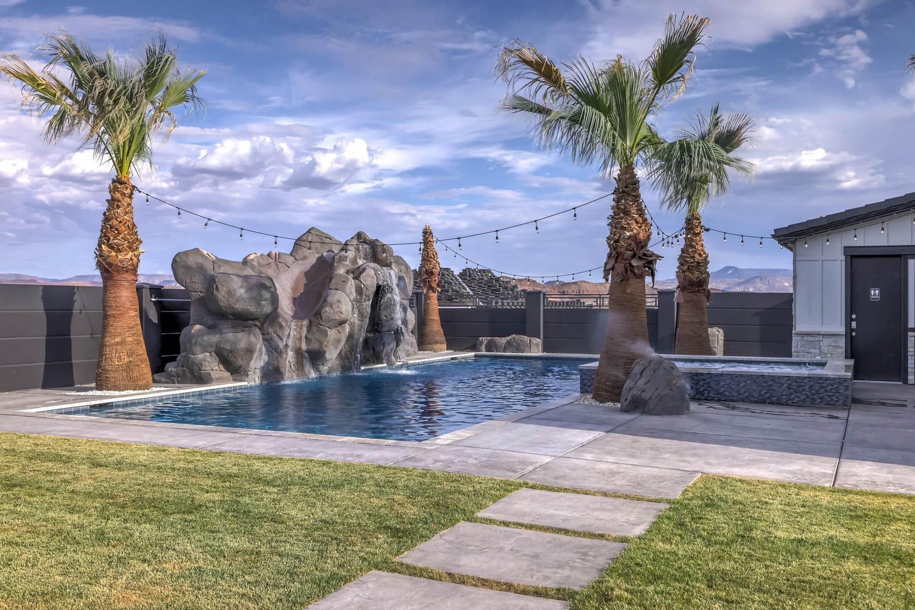 The 20 by 50 foot sports pool with its rock feature and mature palms