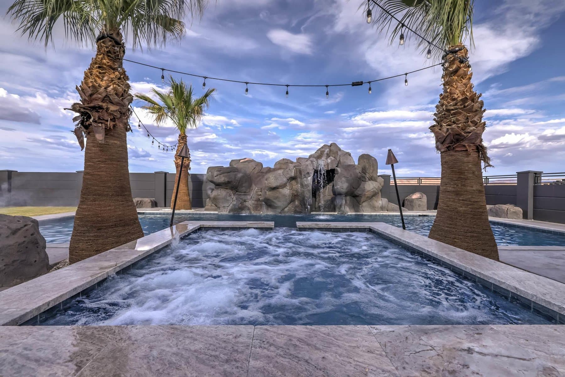 The 20 by 50 foot sports pool with its rock feature and mature palms