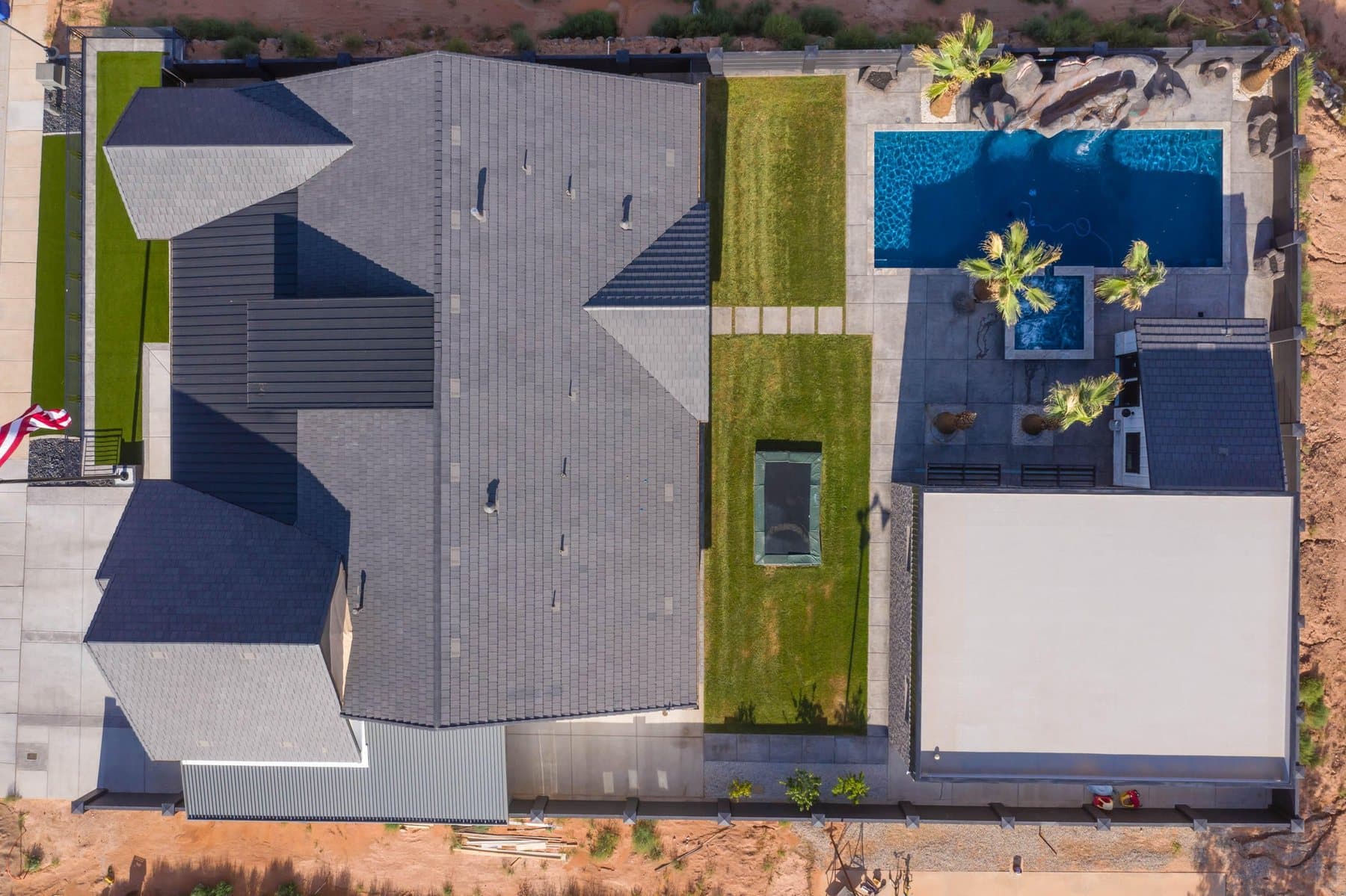 The property from the air — house, pool and courts against the Little Valley ridgeline