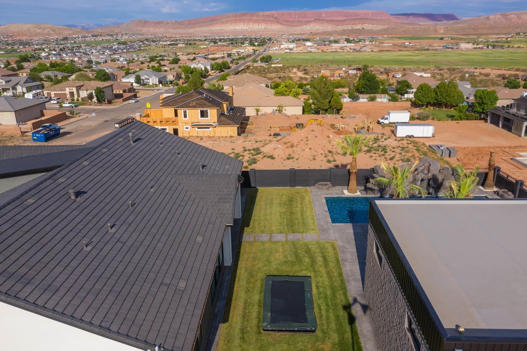 The property from the air — house, pool and courts against the Little Valley ridgeline