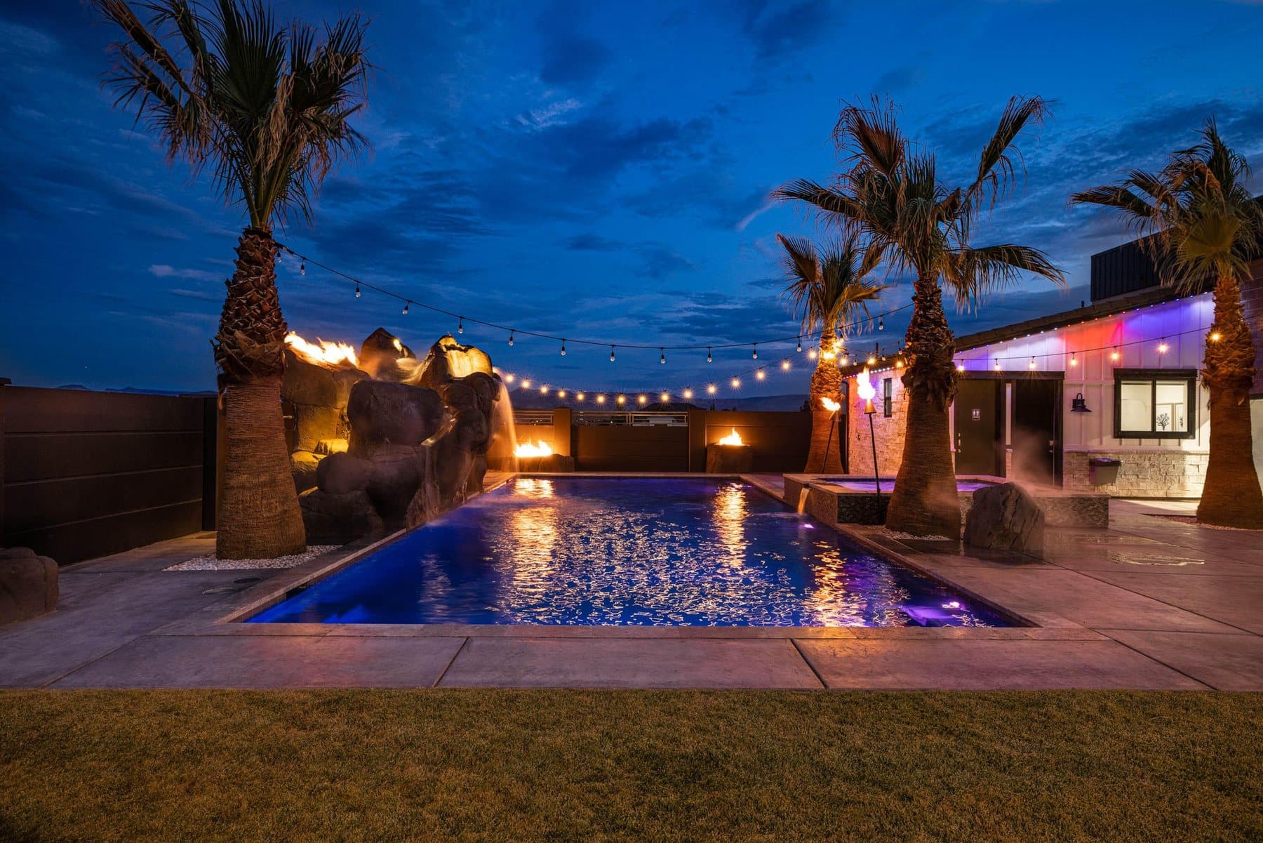 The pool at dusk, lit under string lights