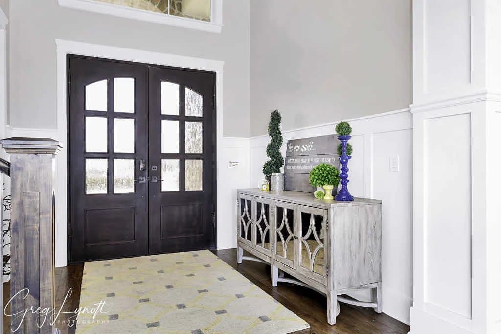 The entry, double doors under a two-storey window