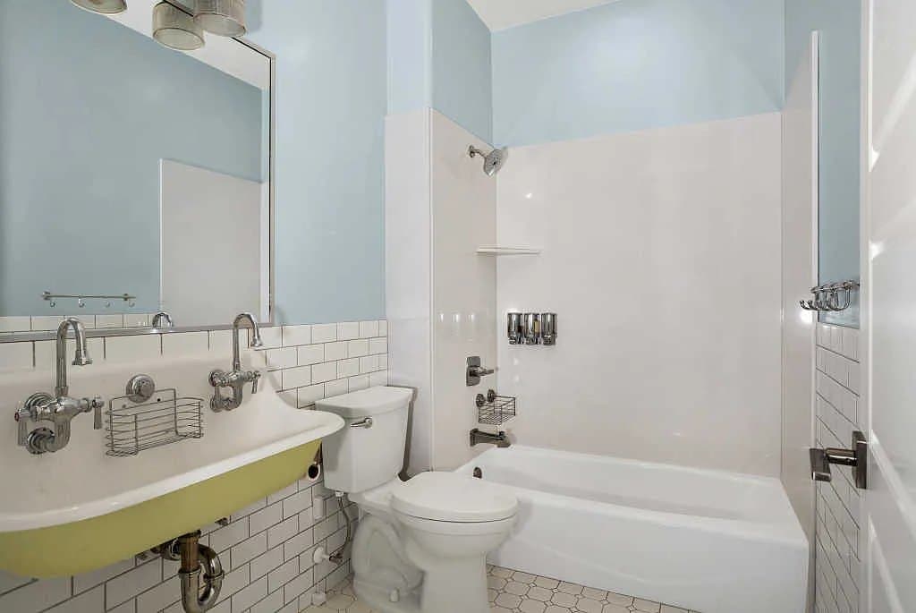 A children's bathroom, trough sink and subway tile