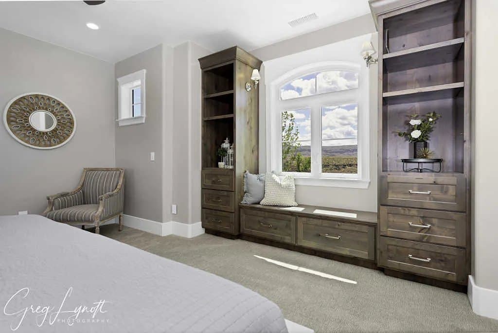 A bedroom with a window seat and built-ins