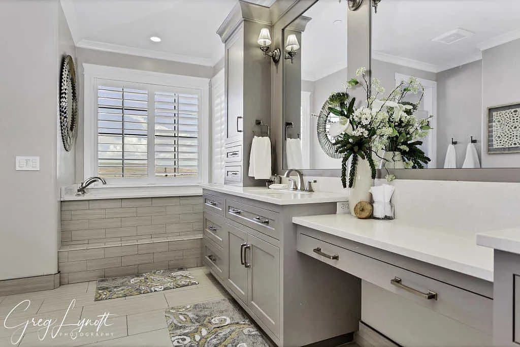 The primary bath — double vanities and a tiled tub surround