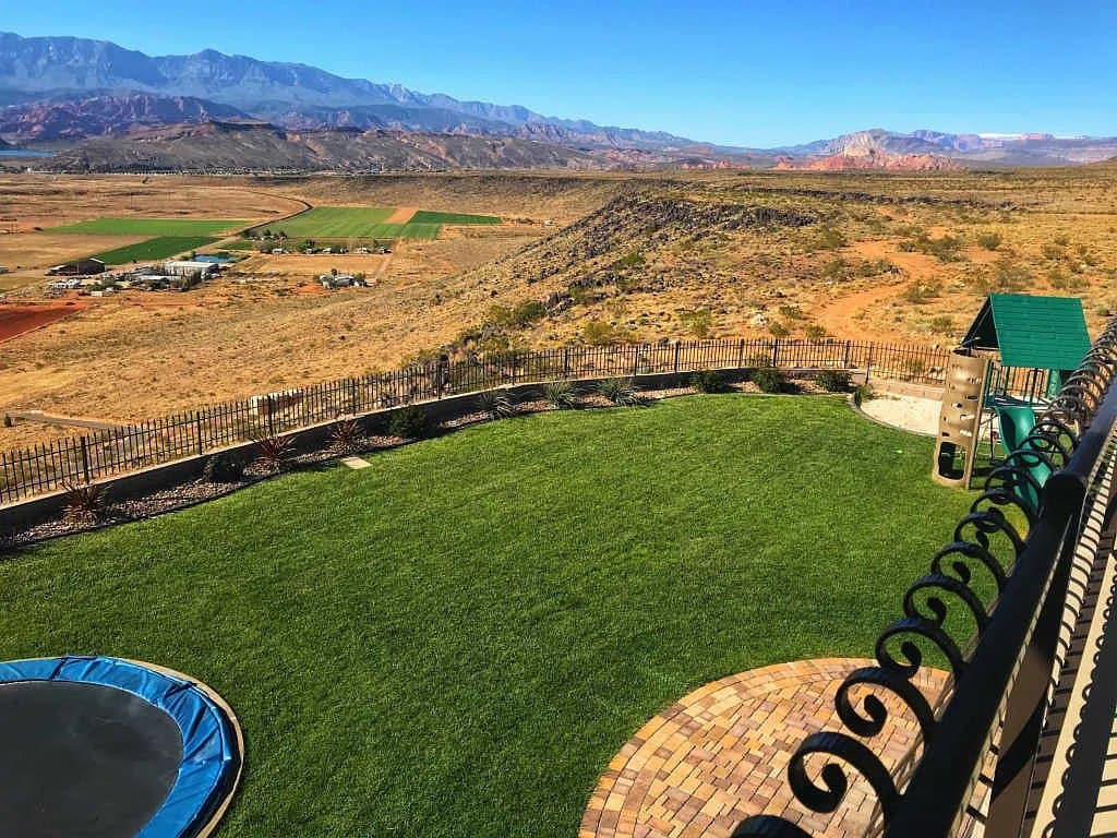 The back lawn — trampoline, playset and the mesa edge